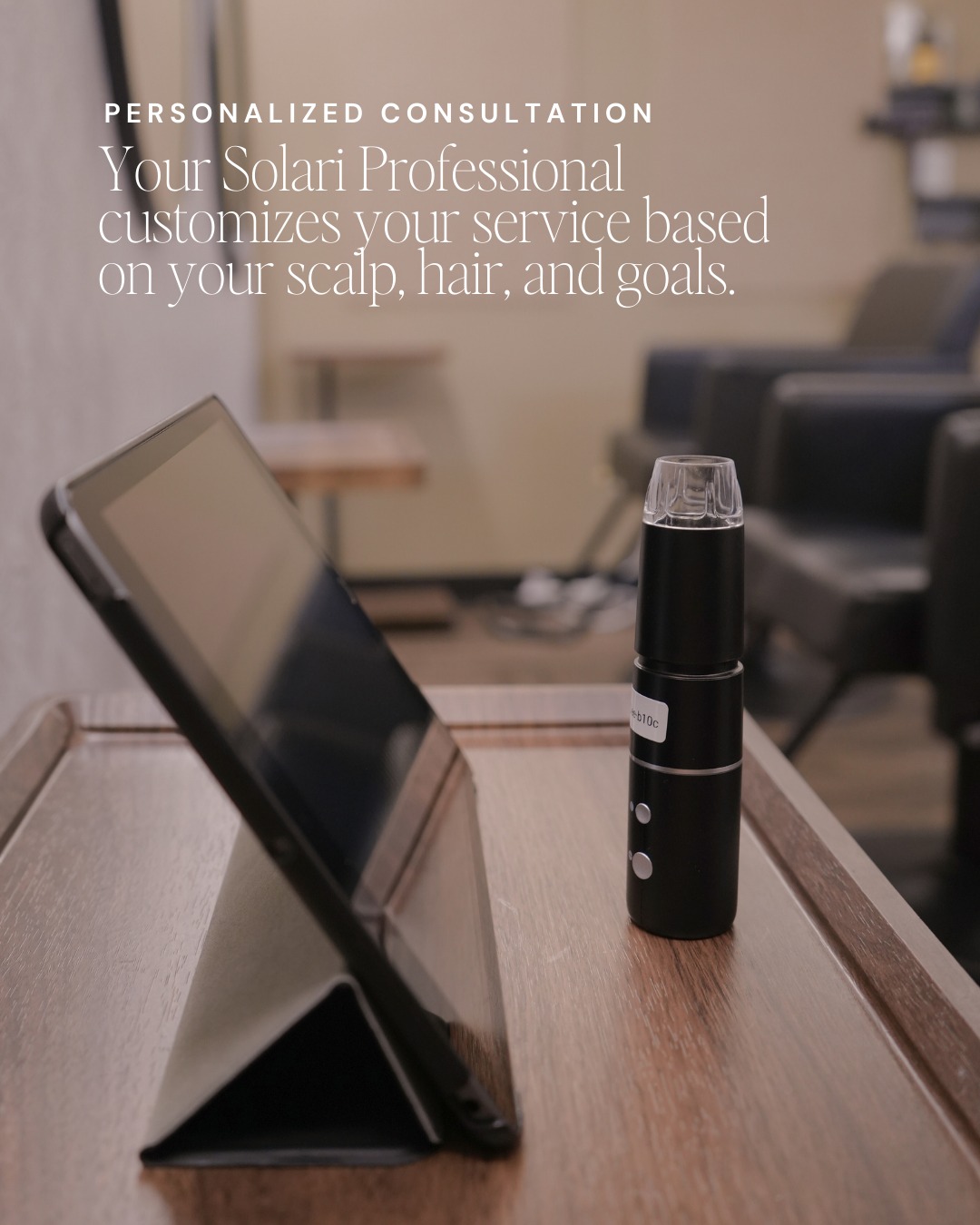 I pad and dermascope sitting on a wooden tray ready to look up close at your scalp.